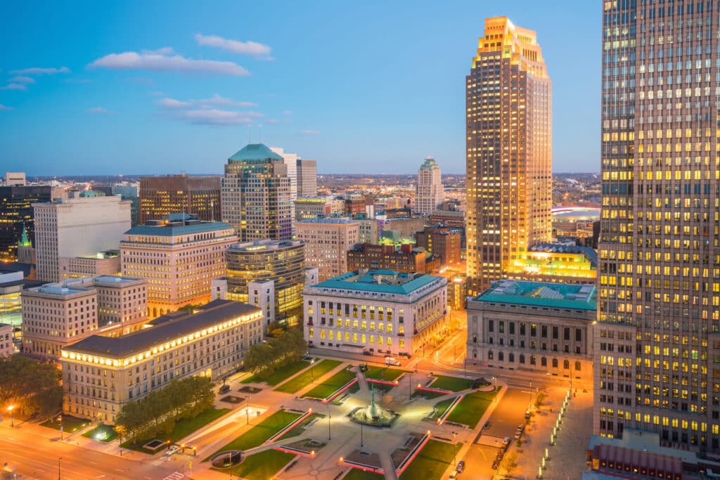 Downtown Cleveland, OH skyline at dusk with illuminated city buildings and streets